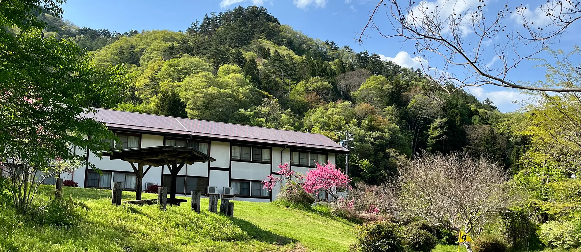 緑と花に囲まれたさぎり荘の外観